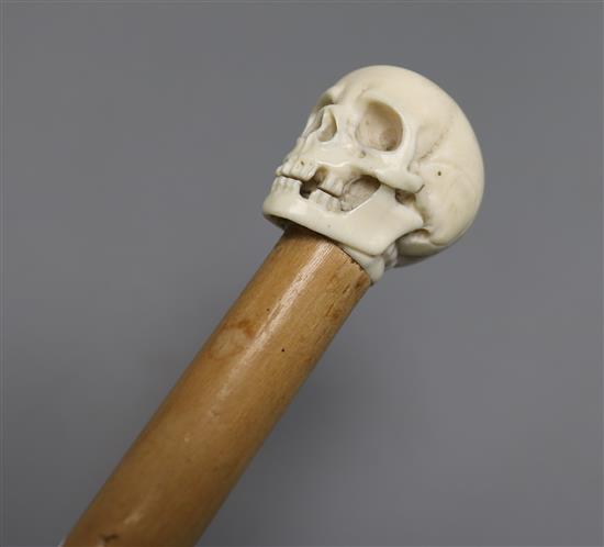 A cane mounted with ivory carving of a skull length 93cm